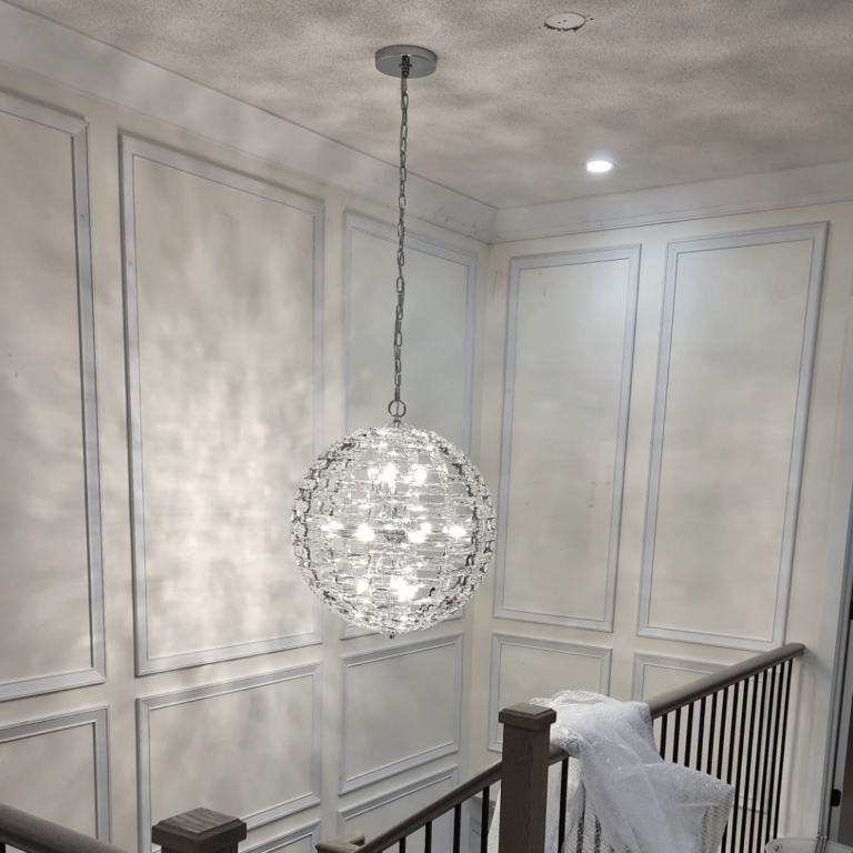 Elegant chandelier installation, adding luxury and sophistication to the staircase area.