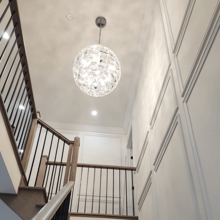Elegant chandelier installation, adding luxury and sophistication to the staircase area.